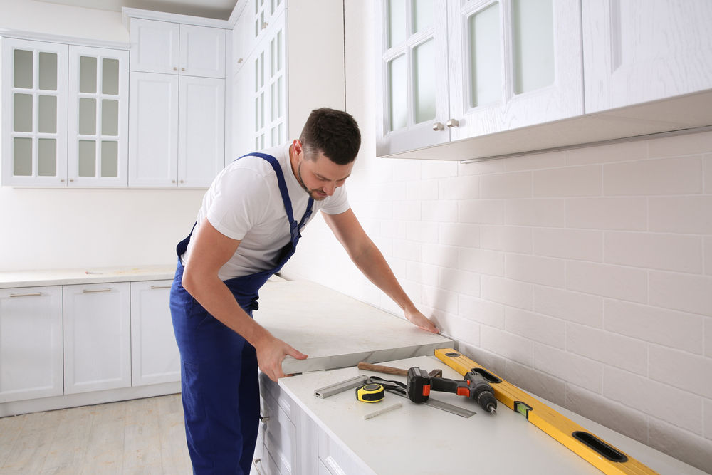 Contractor installing countertop during kitchen remodel [Family Home Improvements]