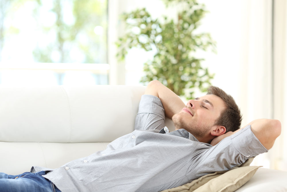 Man relaxing in home (increased comfort due to new windows)